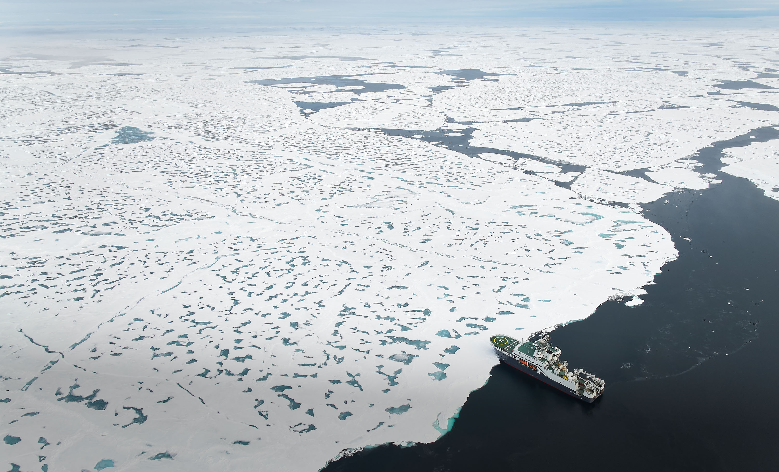 aerial image of the Kronprins Haakon approaching ocean a vast sheet of ocean ice